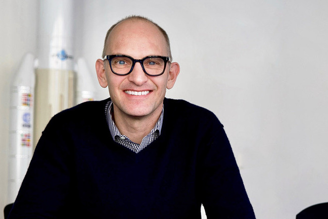 Am Steuer der Schweizer Weltraumpolitik: Vor einem Modell der Ariane 5 präsentiert sich Renato Krpoun, Ratspräsident der Europäischen Weltraumagentur (ESA) und Leiter der Abteilung für Raumfahrt des SBFI in seinem Büro in Bern.  | © Roland J. Keller