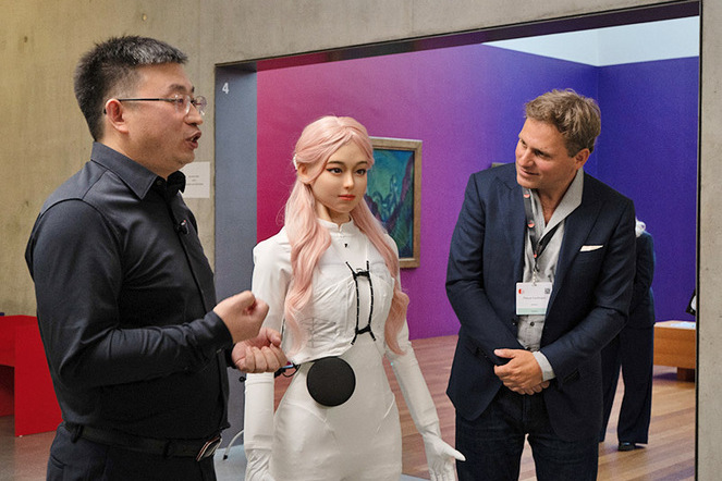 Der humanoide Roboter Moya (Mitte) mit zwei echten Menschen in Davos. | © Davostechsummit