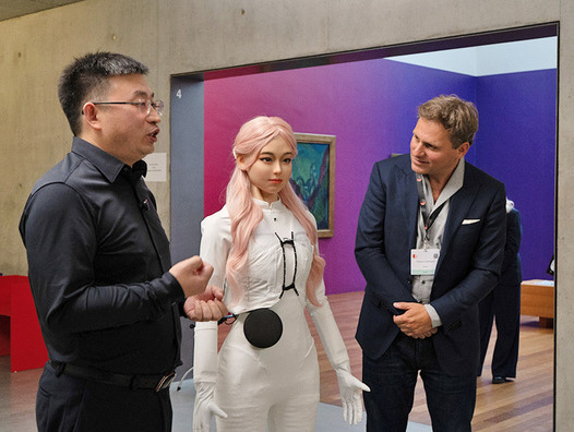 Der humanoide Roboter Moya (Mitte) mit zwei echten Menschen in Davos. | © Davostechsummit